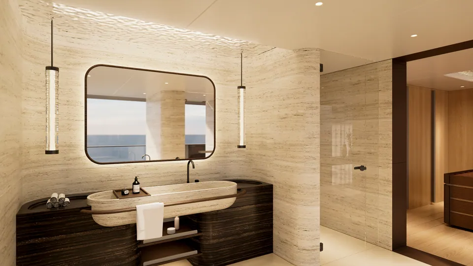 M/Y Waves master cabin ensuite — travertine vanity and sink beneath an ocean-view mirror